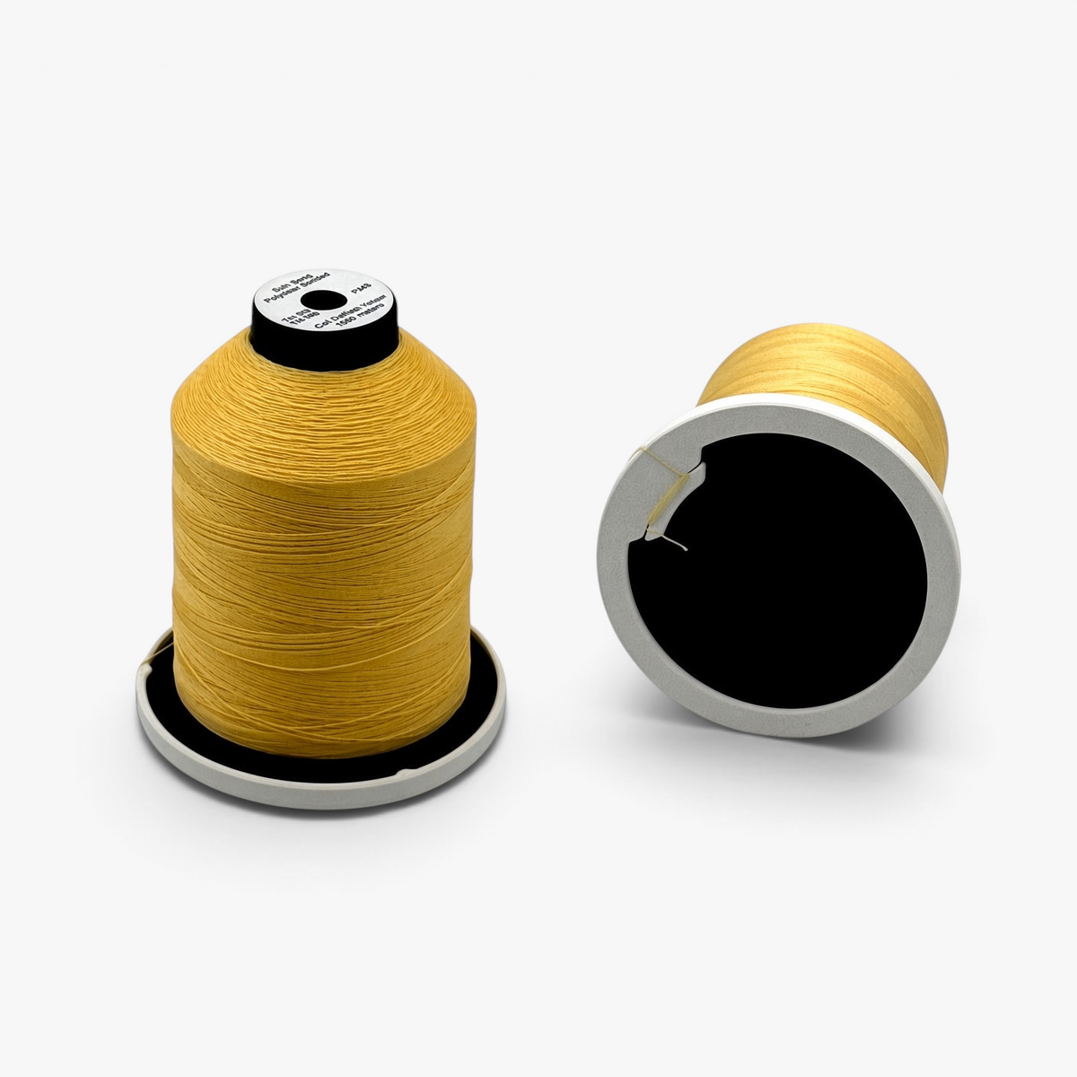 FŪTL Spool Savers attached to yellow industrial thread spools with integrated tangle tabs for secure storage